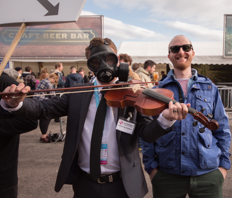 Festival Insights' Tom Lawson (right) with Man In Gas Mask With Violin (left)